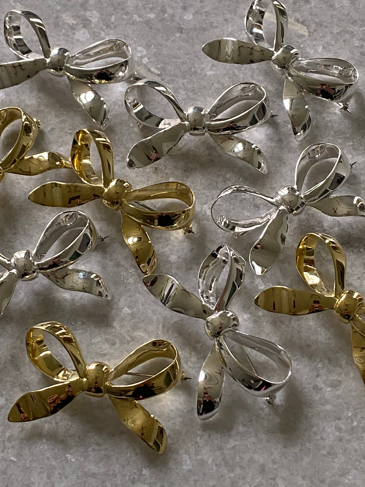 a group of silver and gold metal bows sit on marble