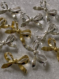 a group of silver and gold metal bows sit on marble