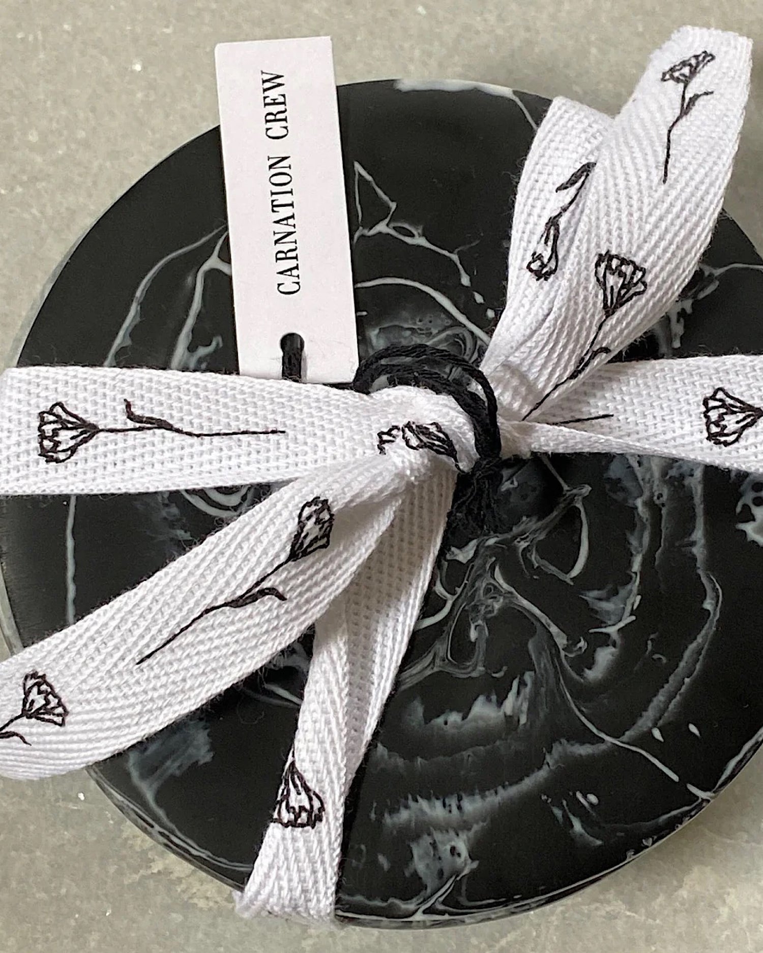 set 4 black and white mottled coasters tied up with white ribbon