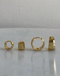 A pair of gold-colored hoop earrings with a textured faceted design, displayed on a white background.