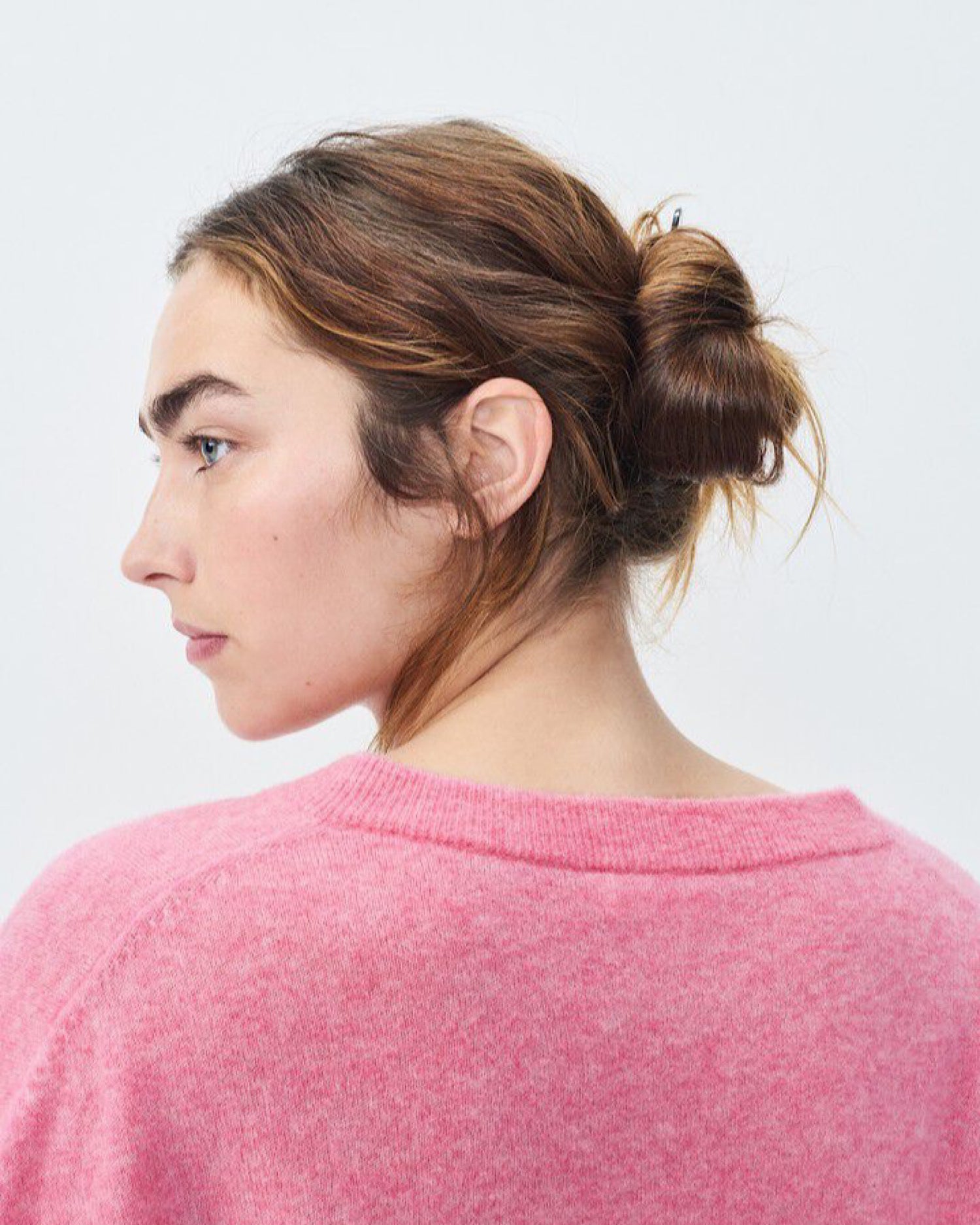 Model wears a pink v neck Razow Sweater from American Vintage