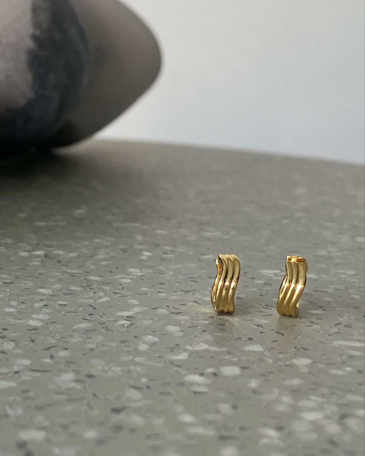 A gold pair a wave shaped small hoops