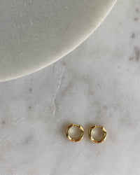 A gold pair a wave shaped small hoops