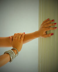 Model wears varying sizes of snake bangle
