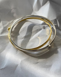 simple thin gold bangle with a single pearl inlaid half way around it