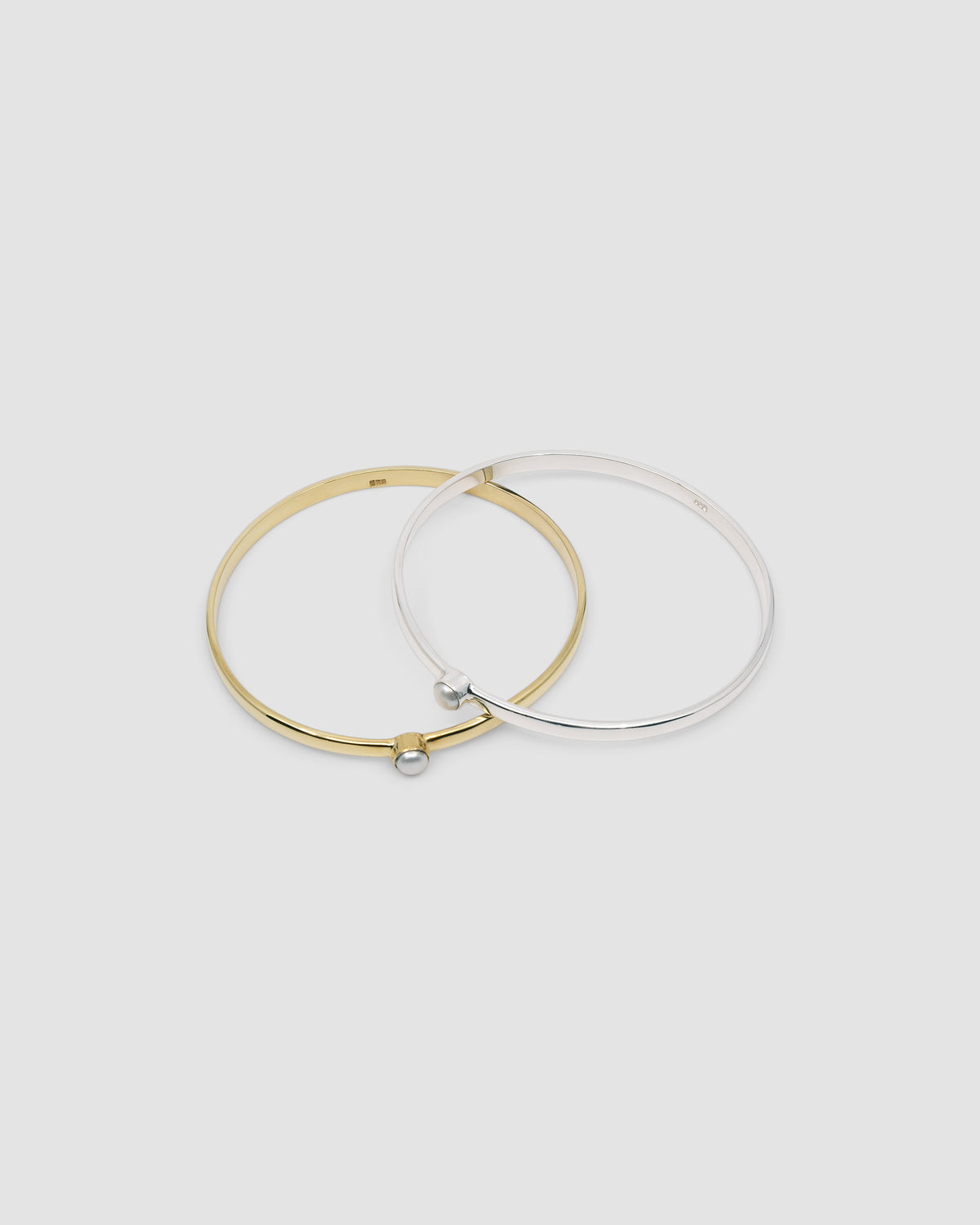simple thin gold bangle with a single pearl inlaid half way around it