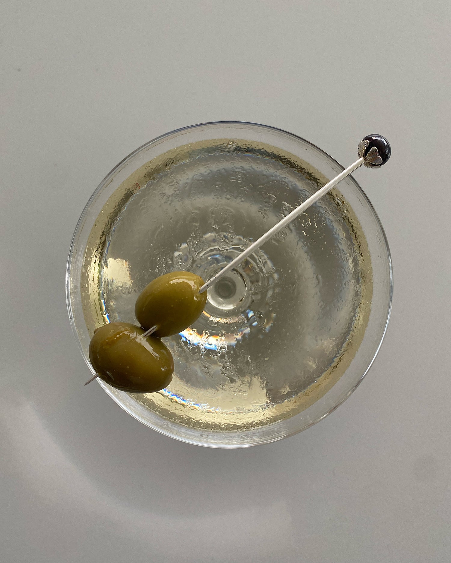 a martini pick with a black pearl