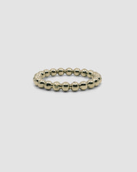 side view of a gold bubble bangle on grey background