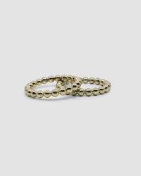 Two brass ball bangles rest on each other