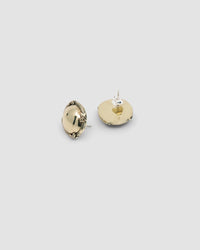 brass round earrings with a cross detail on edge sit on a greay background