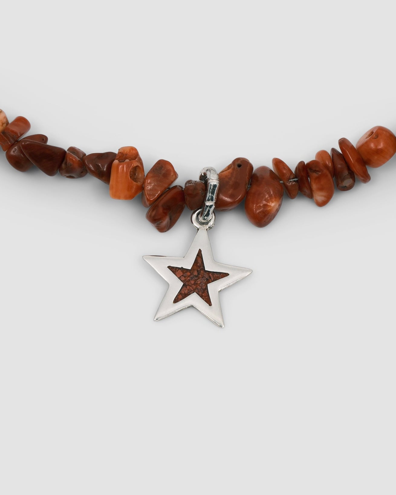 a red coral jagged necklace with a central coral and silver star