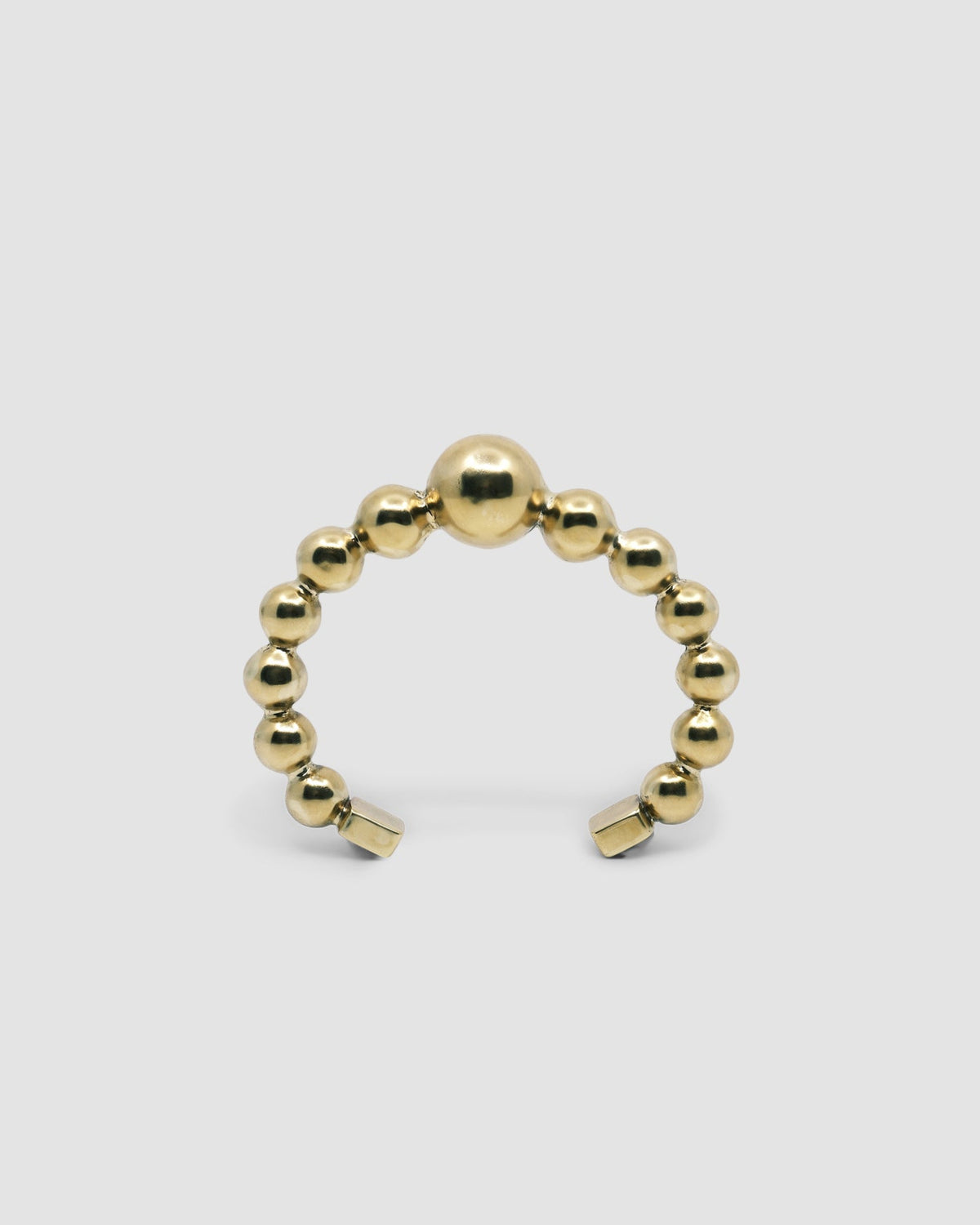 an open gold cuff bangle consisting of numerous interlinked gold balls