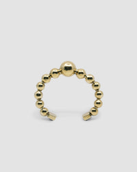 an open gold cuff bangle consisting of numerous interlinked gold balls
