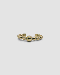an open gold cuff bangle consisting of numerous interlinked gold balls
