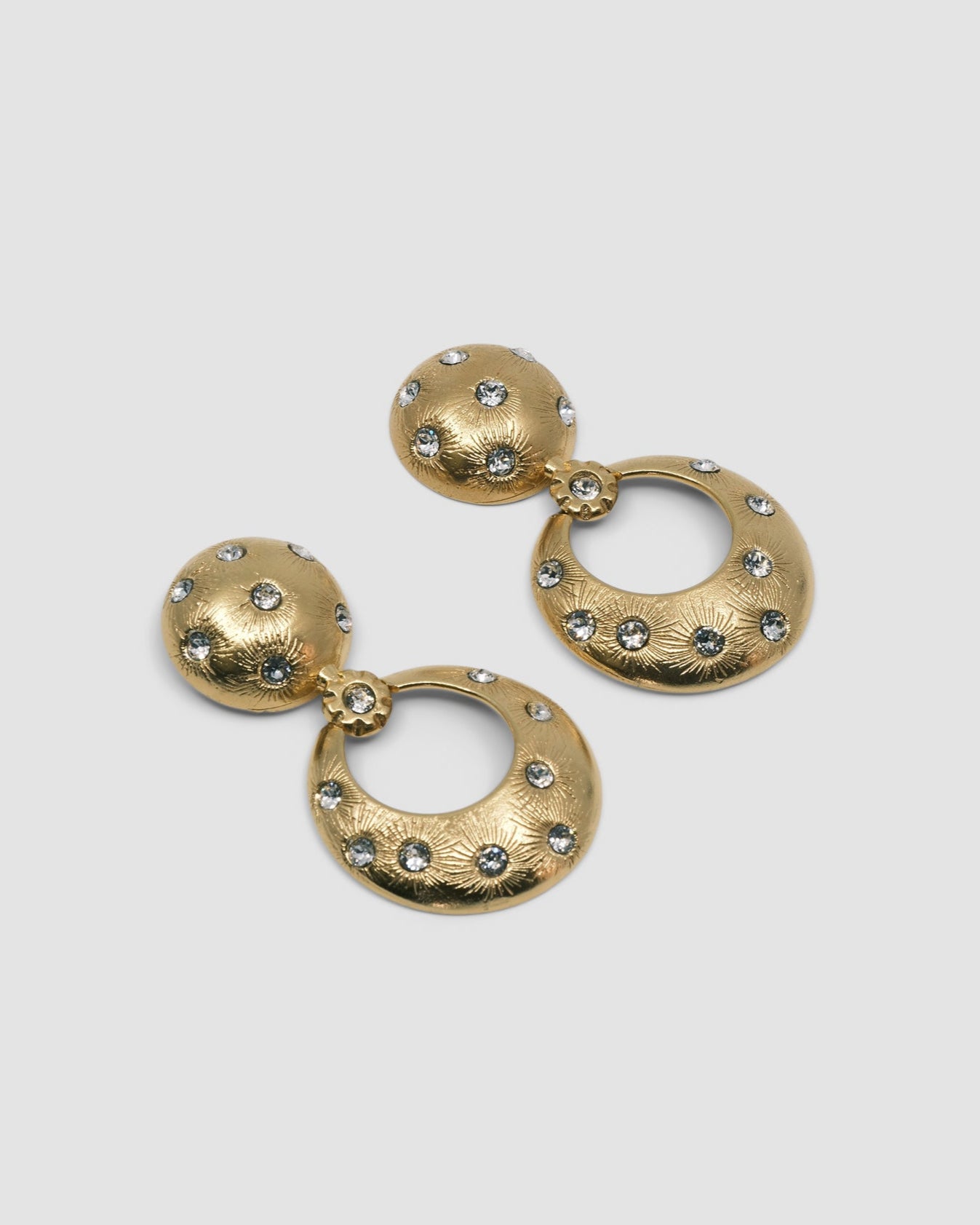 Gold earrings featuring a round stud top and open circle drop inlaid with crystals