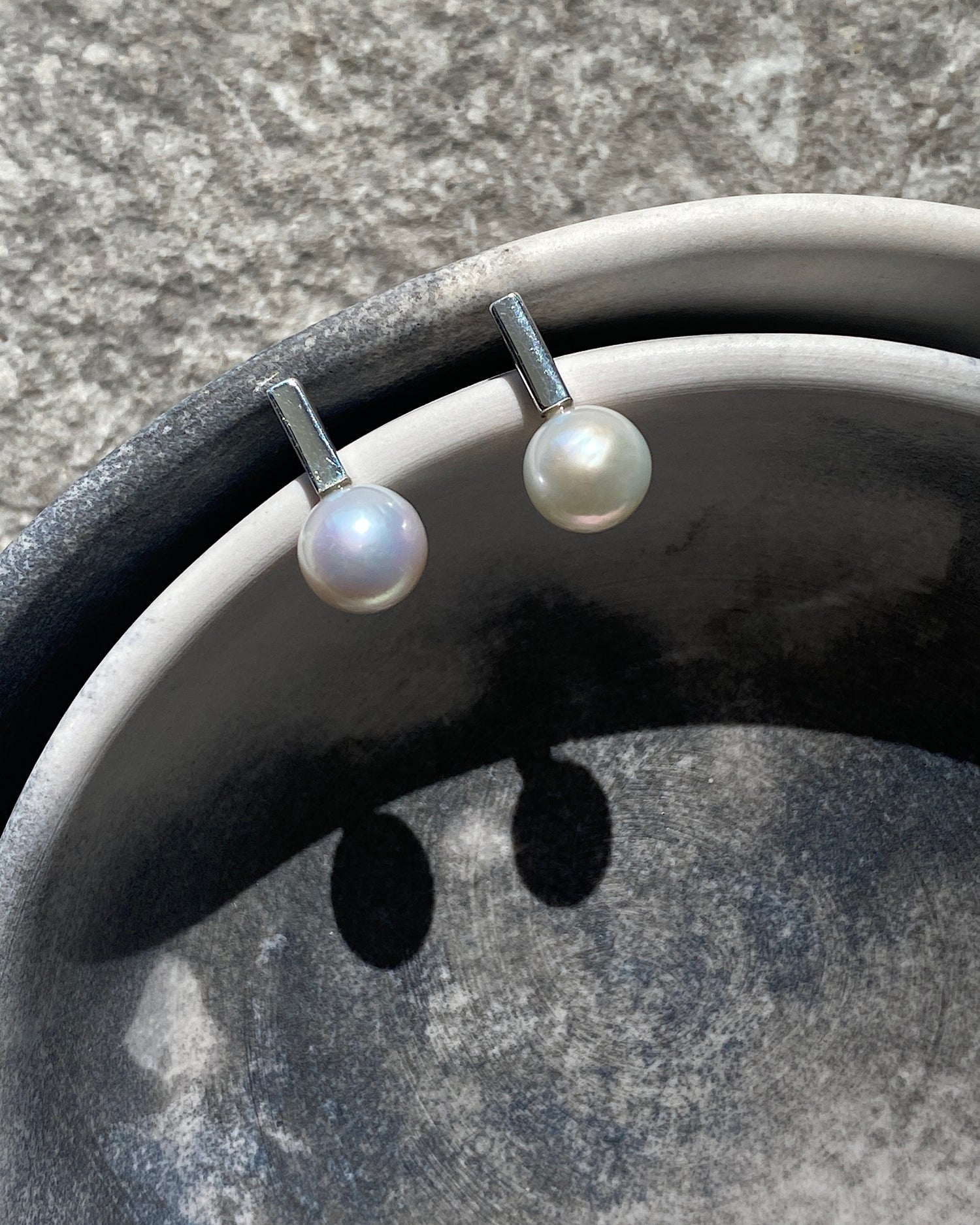 thin short silver bar earrings with pearls attached sit in a bowl. Available at The Pared Store, 16 Foster St, Surry Hills