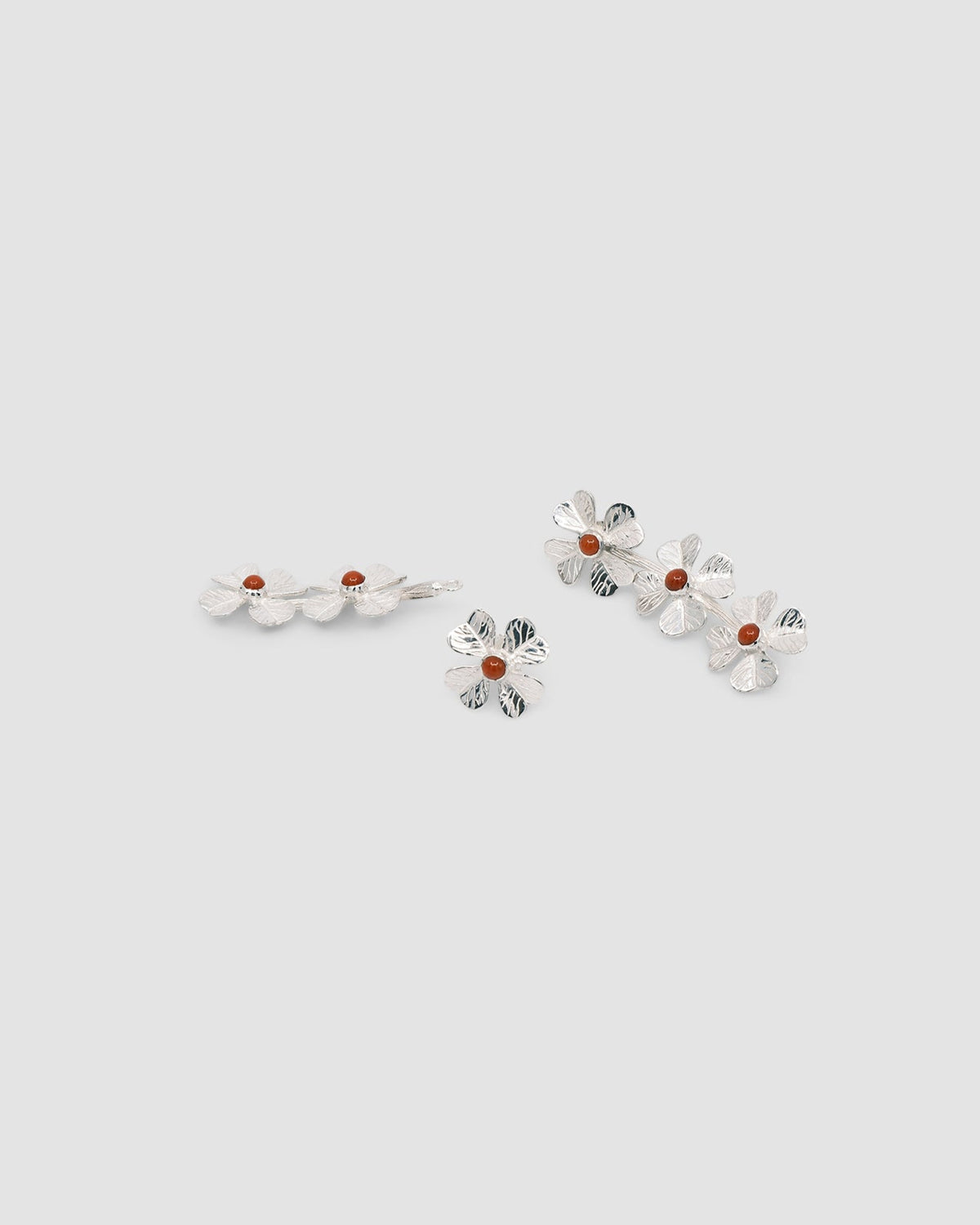 Silver four leaf clover earrings with a central coral stone