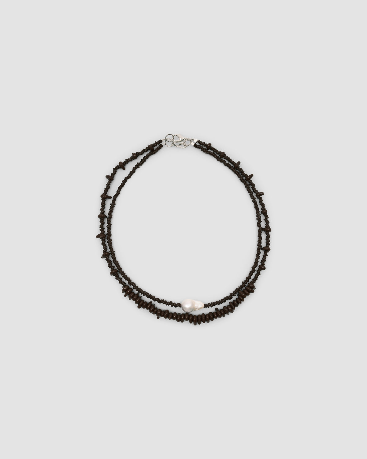 chocolate irregular glass bead necklace sits with a pearl and bead necklace in the same colour