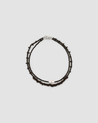 chocolate irregular glass bead necklace sits with a pearl and bead necklace in the same colour
