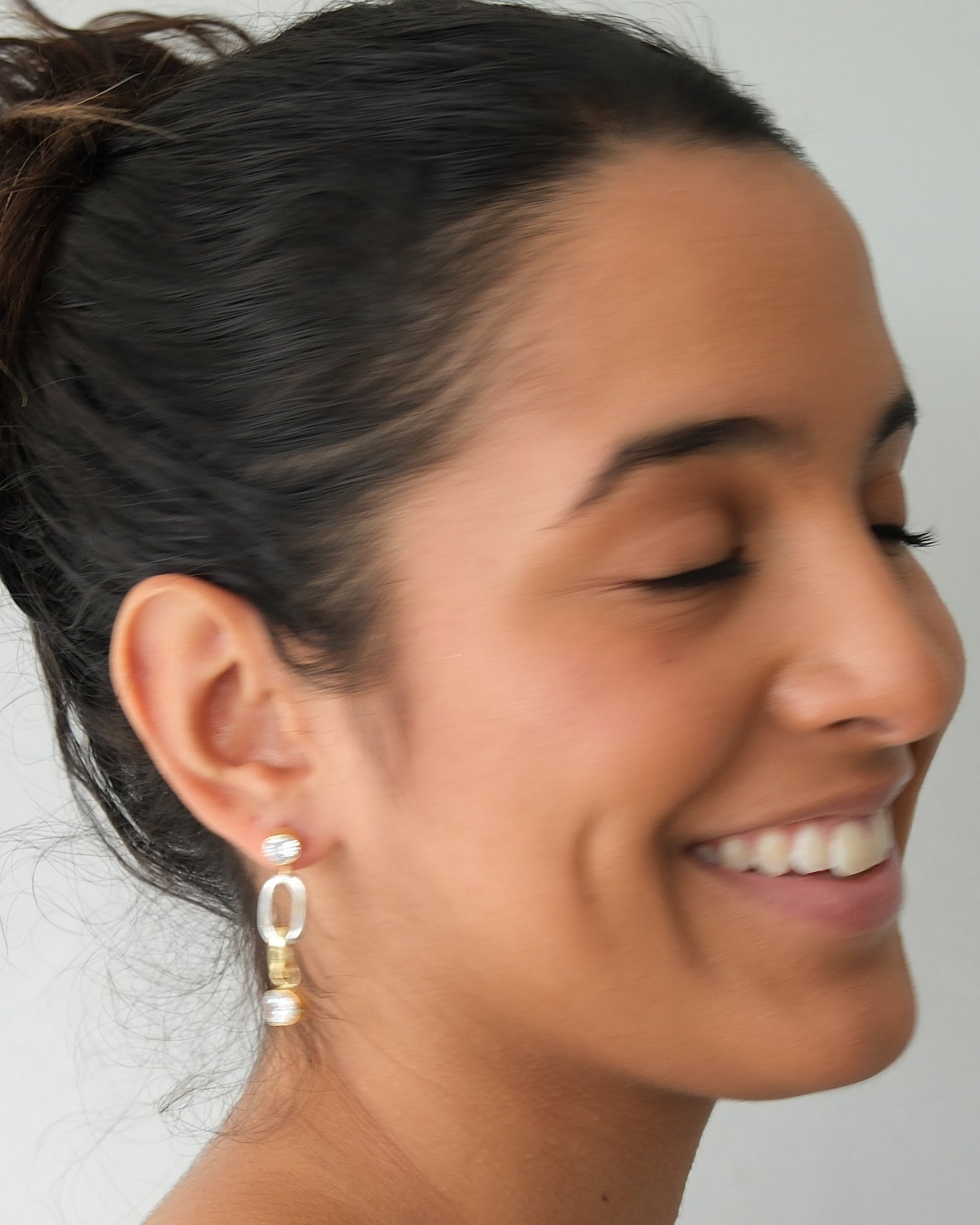 model wears a crystal and mixed metal earring