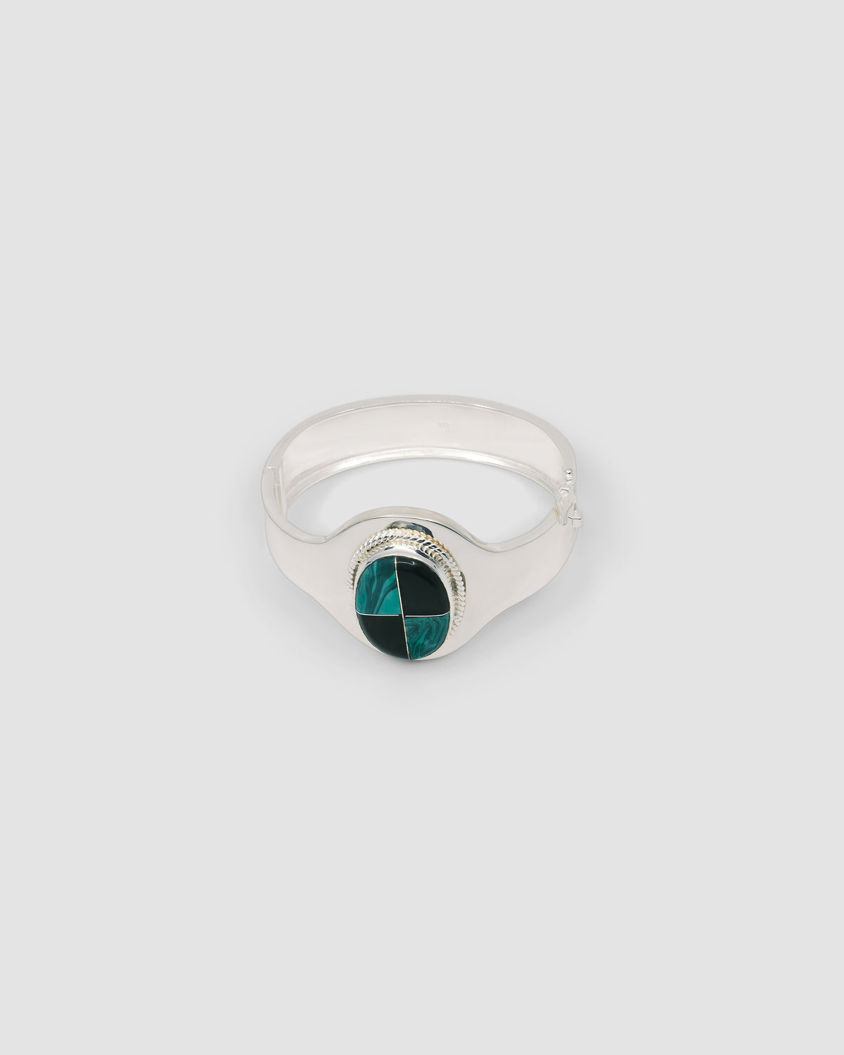 silver cuff bracelet with an inlaid black and green stone