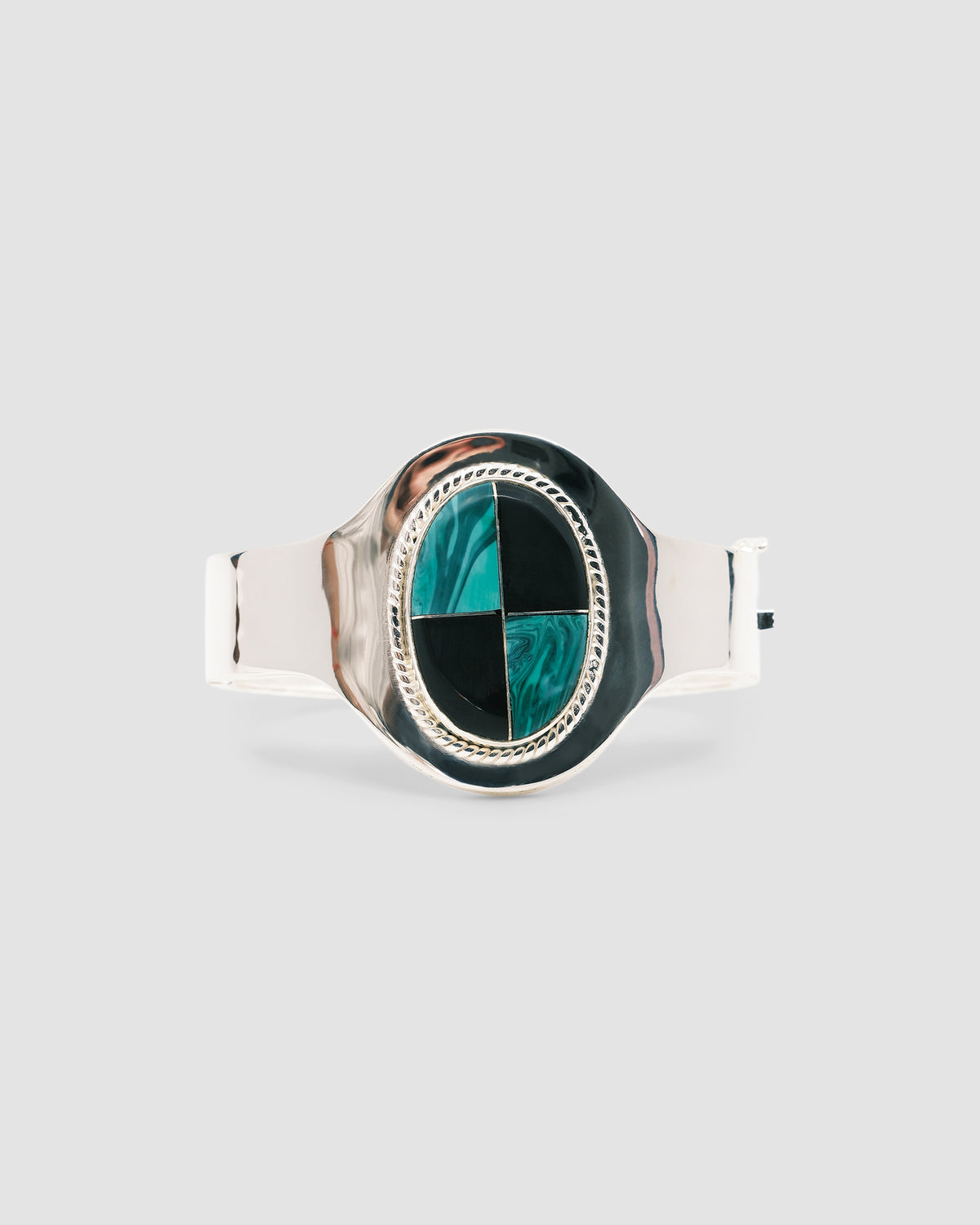 silver cuff bracelet with an inlaid black and green stone