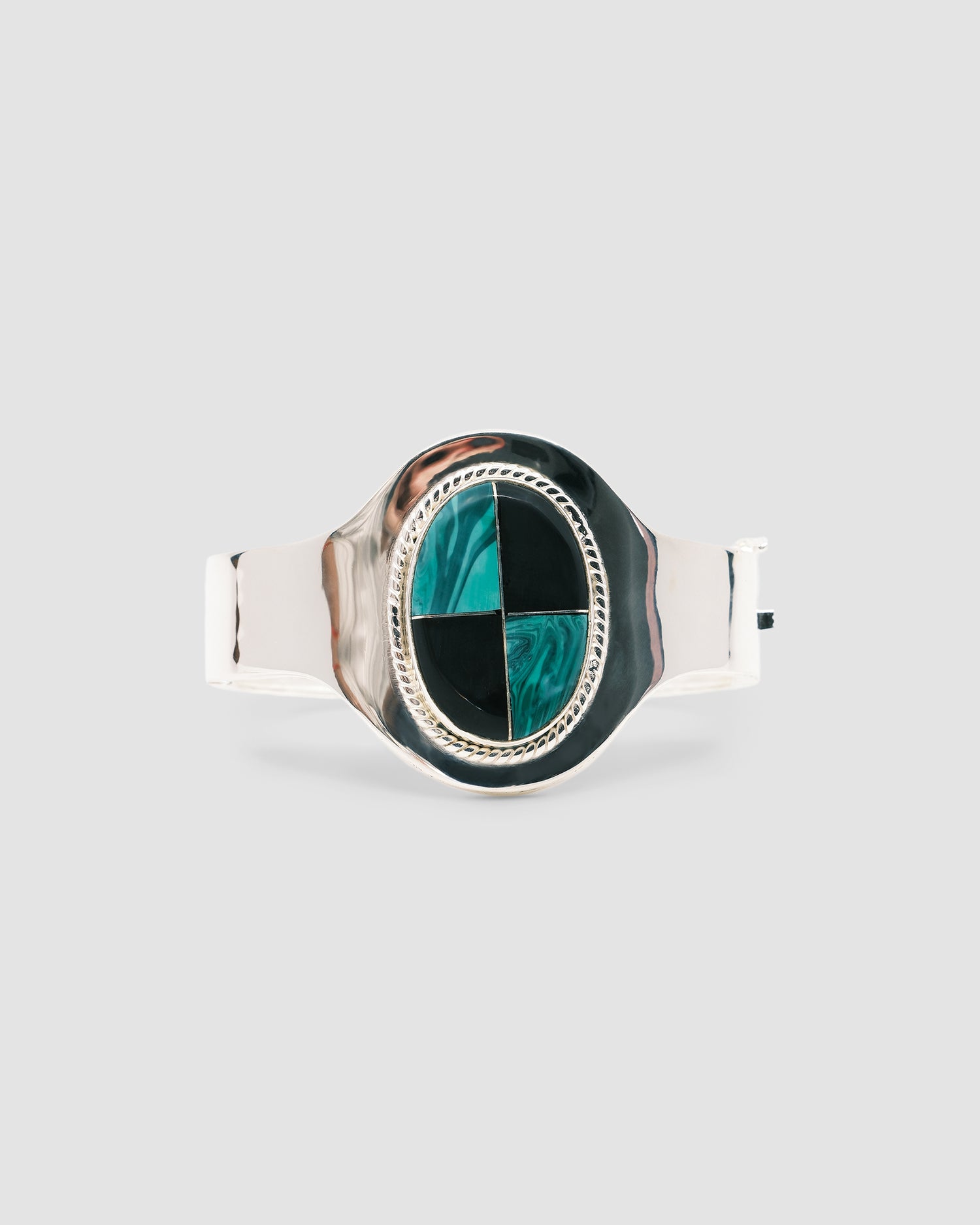 silver cuff bracelet with an inlaid black and green stone