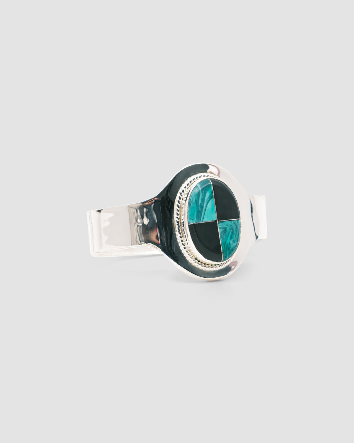 silver cuff bracelet with an inlaid black and green stone