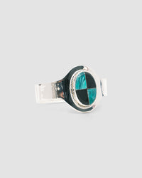 silver cuff bracelet with an inlaid black and green stone