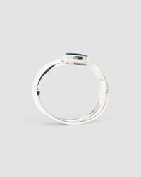 silver cuff bracelet with an inlaid black and green stone