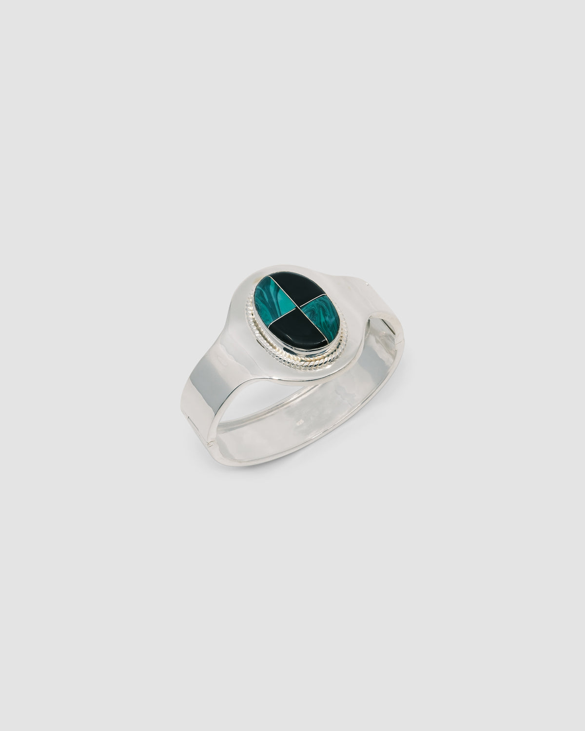 silver cuff bracelet with an inlaid black and green stone