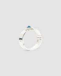 a silver cuff bracelet with a green sqaure stone set into it and beading around the exterior