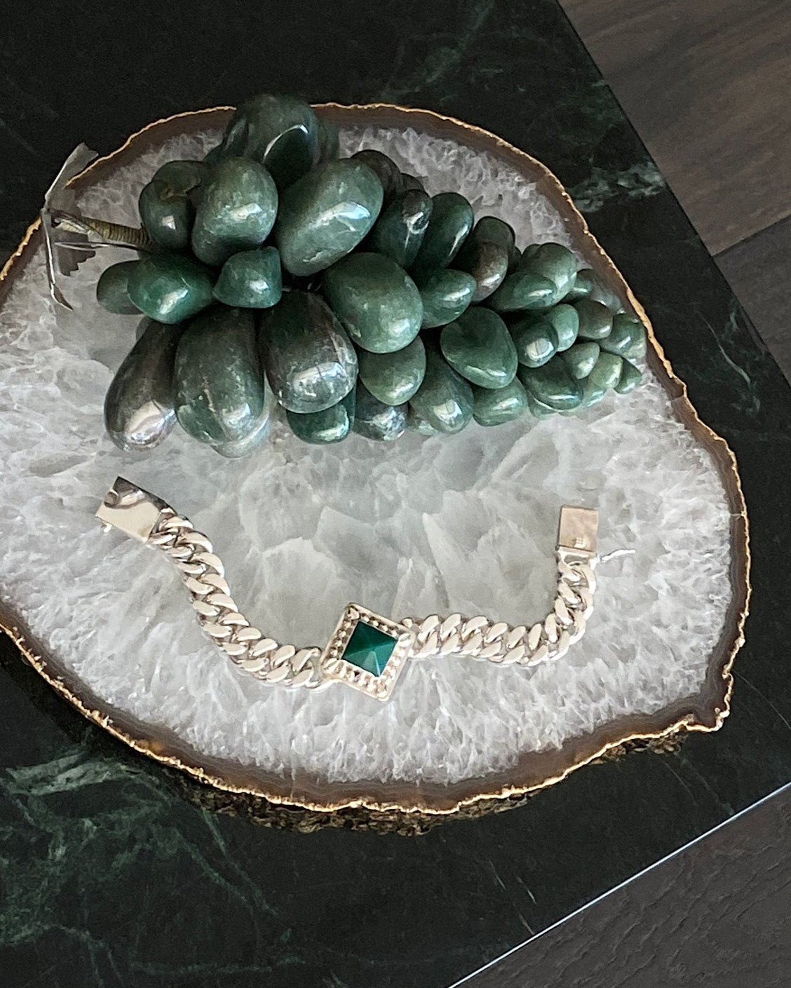 silver cuban chain bracelet set with a square pendant set with a green pyramid shaped stone