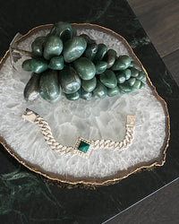 silver cuban chain bracelet set with a square pendant set with a green pyramid shaped stone