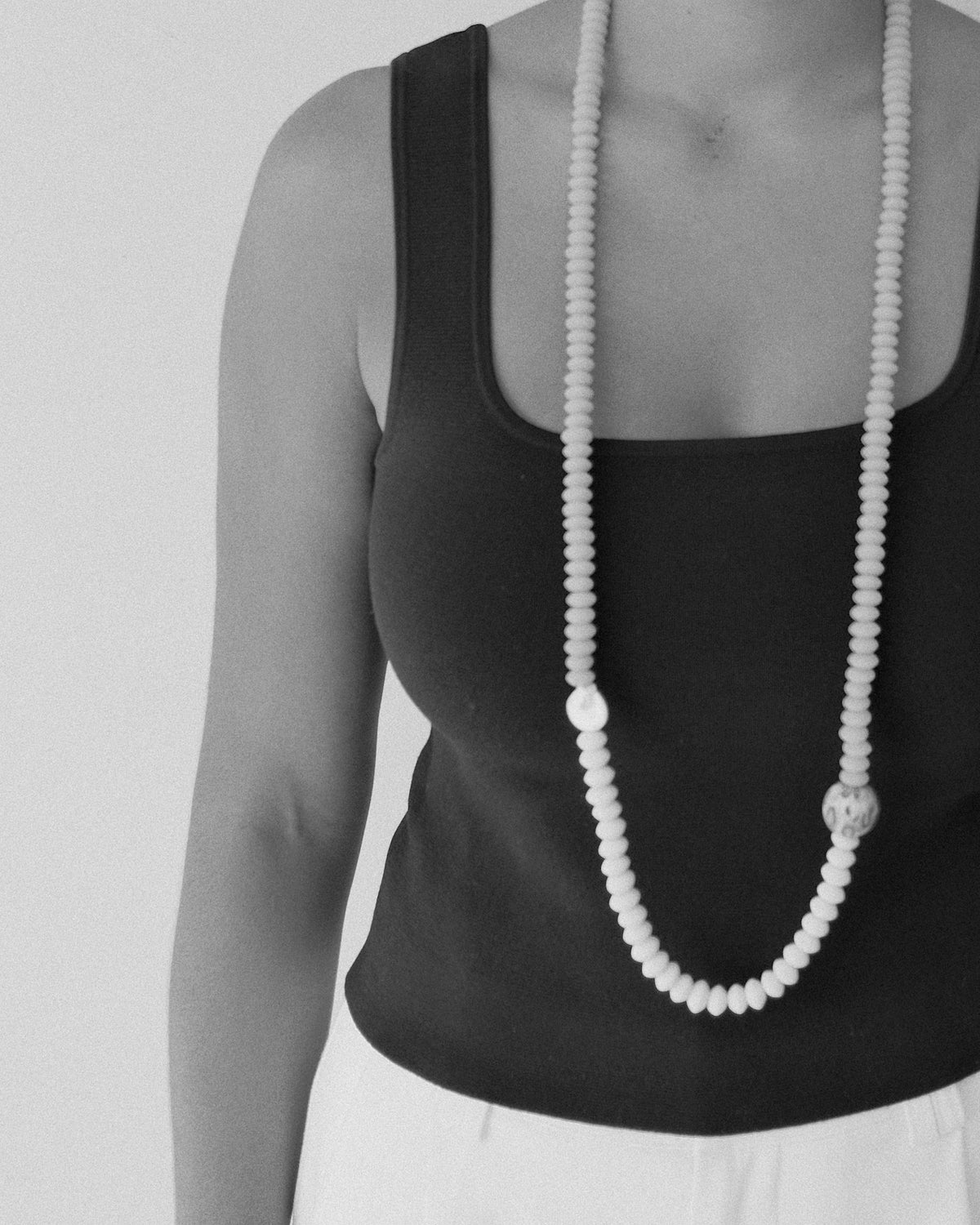 model wears a long beaded necklace with a pearl and feature large handmade bead