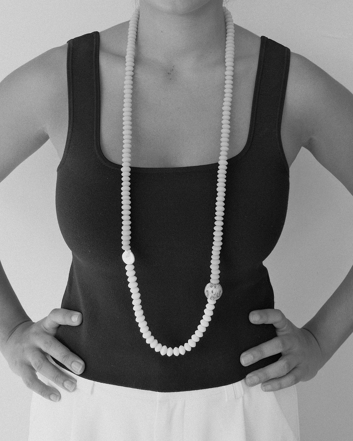 model wears a long beaded necklace with a pearl and feature large handmade bead