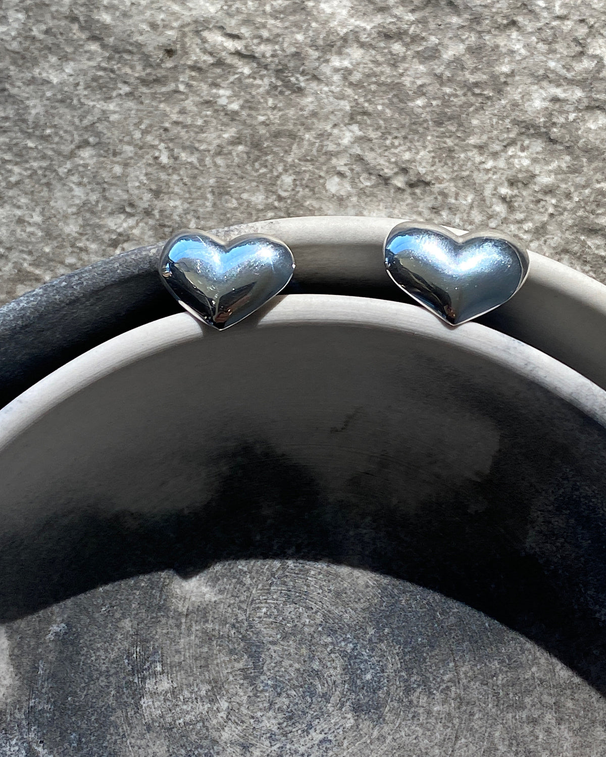silver hearty earrings in a bowl