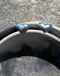silver hearty earrings in a bowl