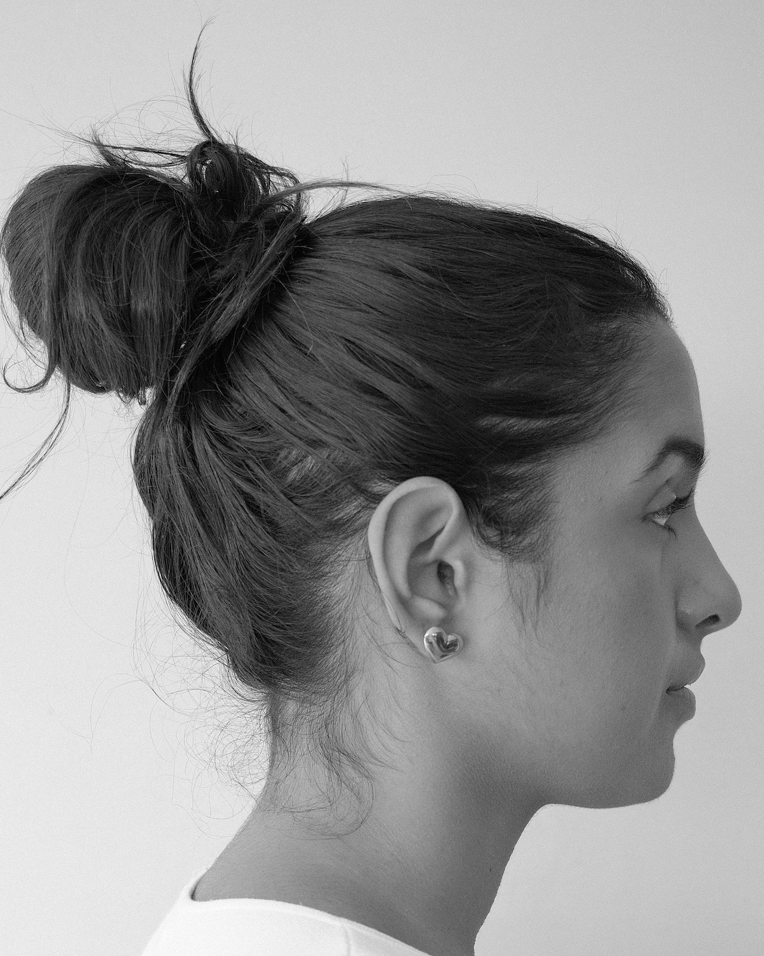 model wears gold heart stud earrings