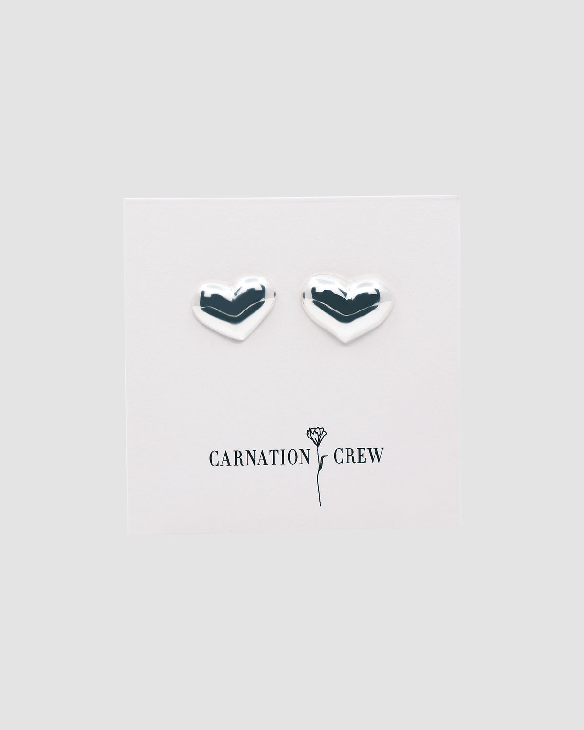 silver heart earrings on a branded card
