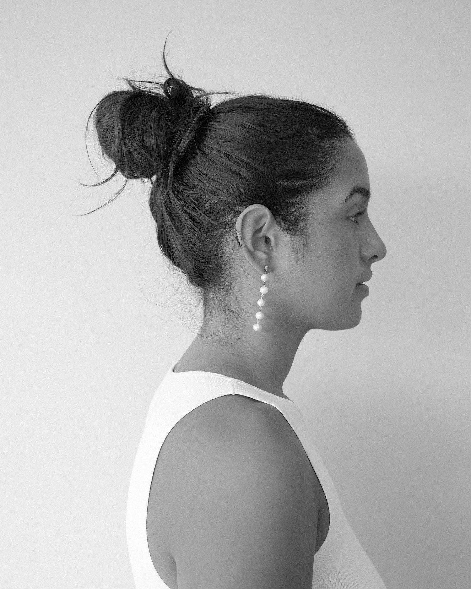 model wears long multiple pearl earrings