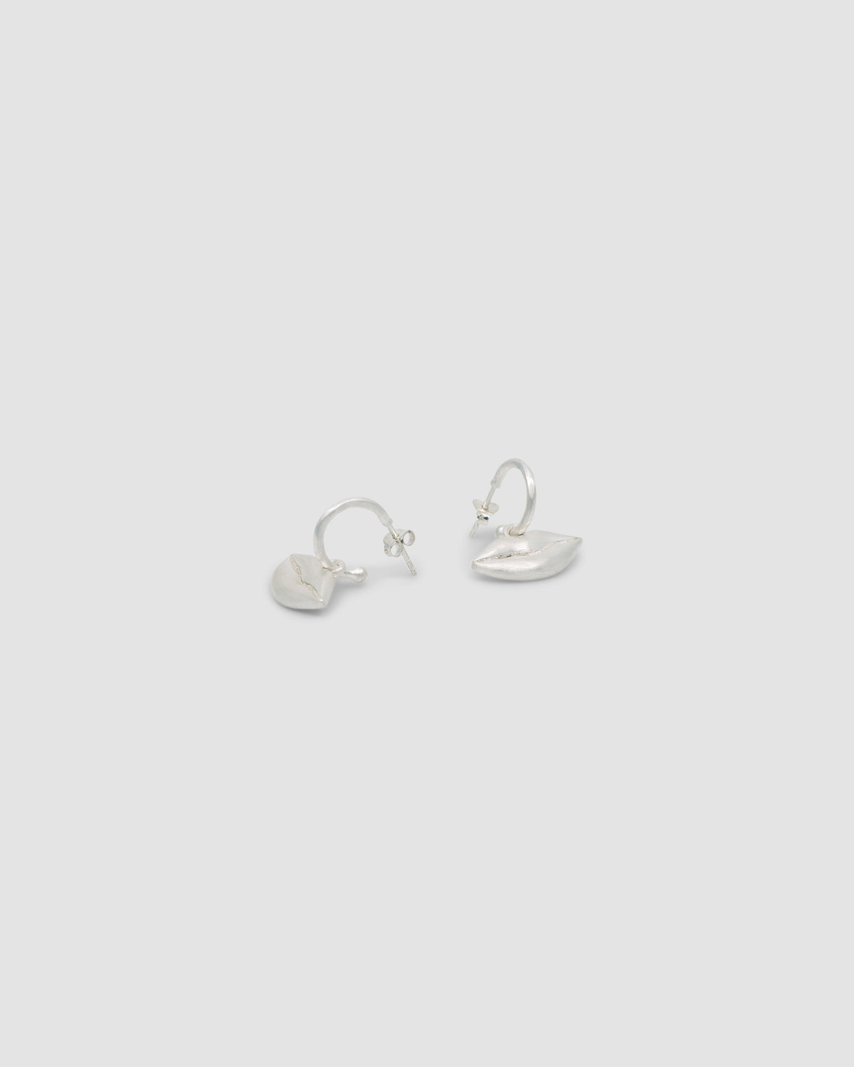 Matt silver lips are suspended from matt silver hoop earrings
