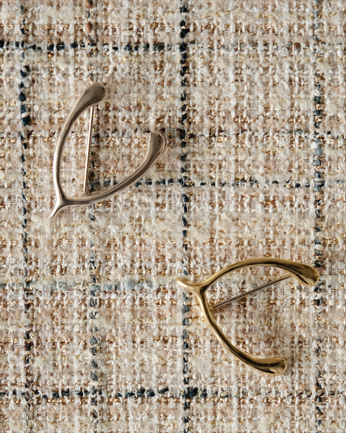a pair of gold & silver wishbone brooches