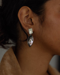 Model wears abalone and silver earrings from The Pared Store, Australia