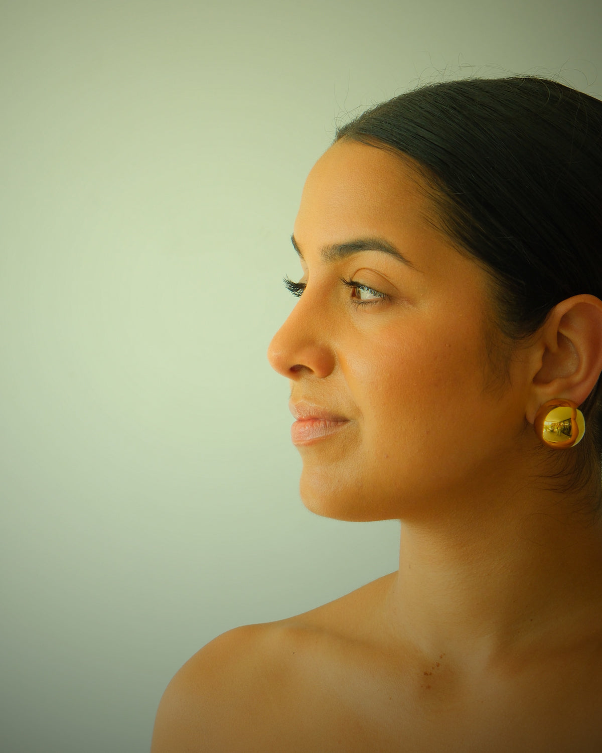 Model wears Alexandra Clip on gold ball earrings