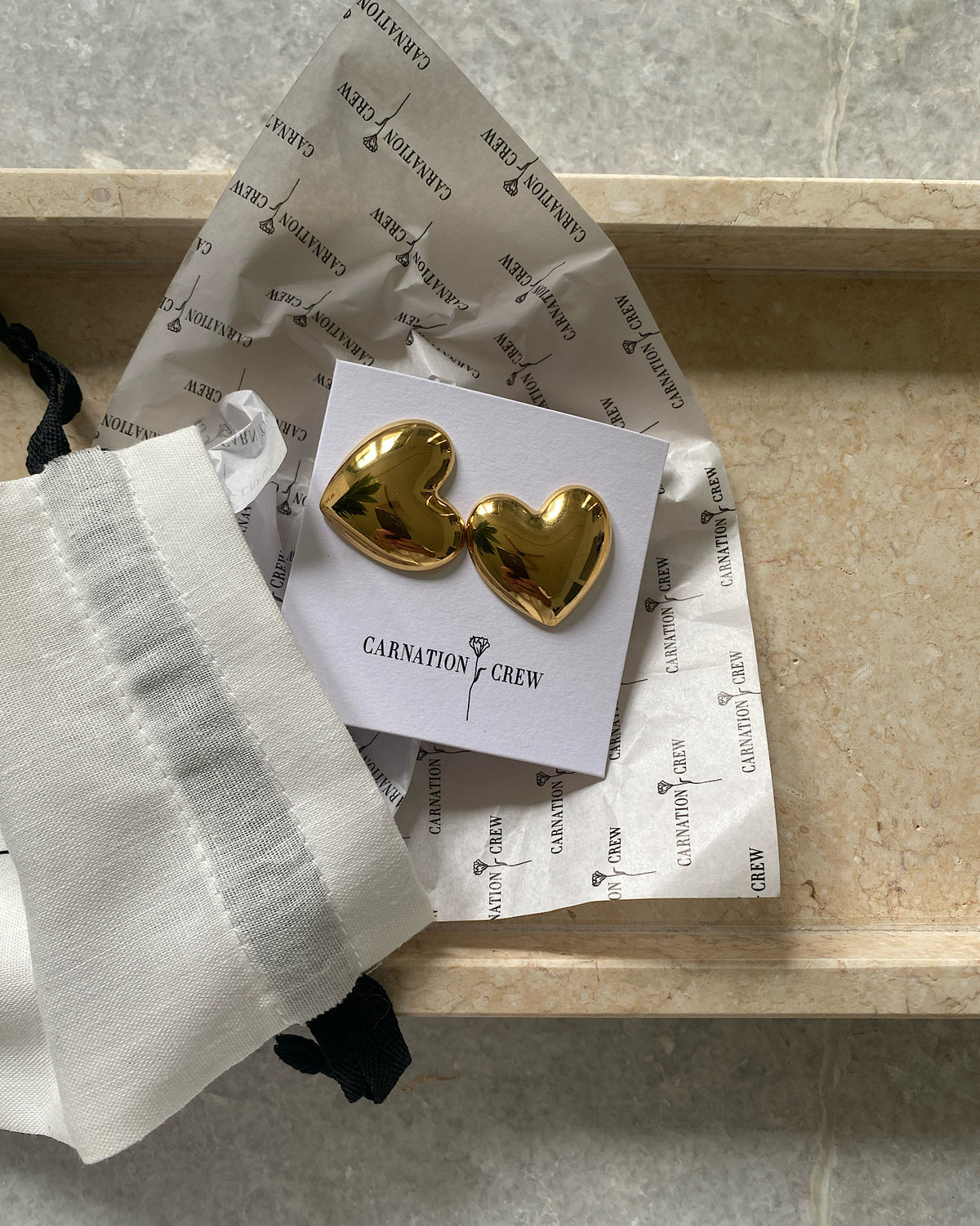 Baby gold heart earrings in a tray