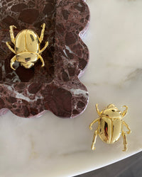 a gold christmas beetle brooch