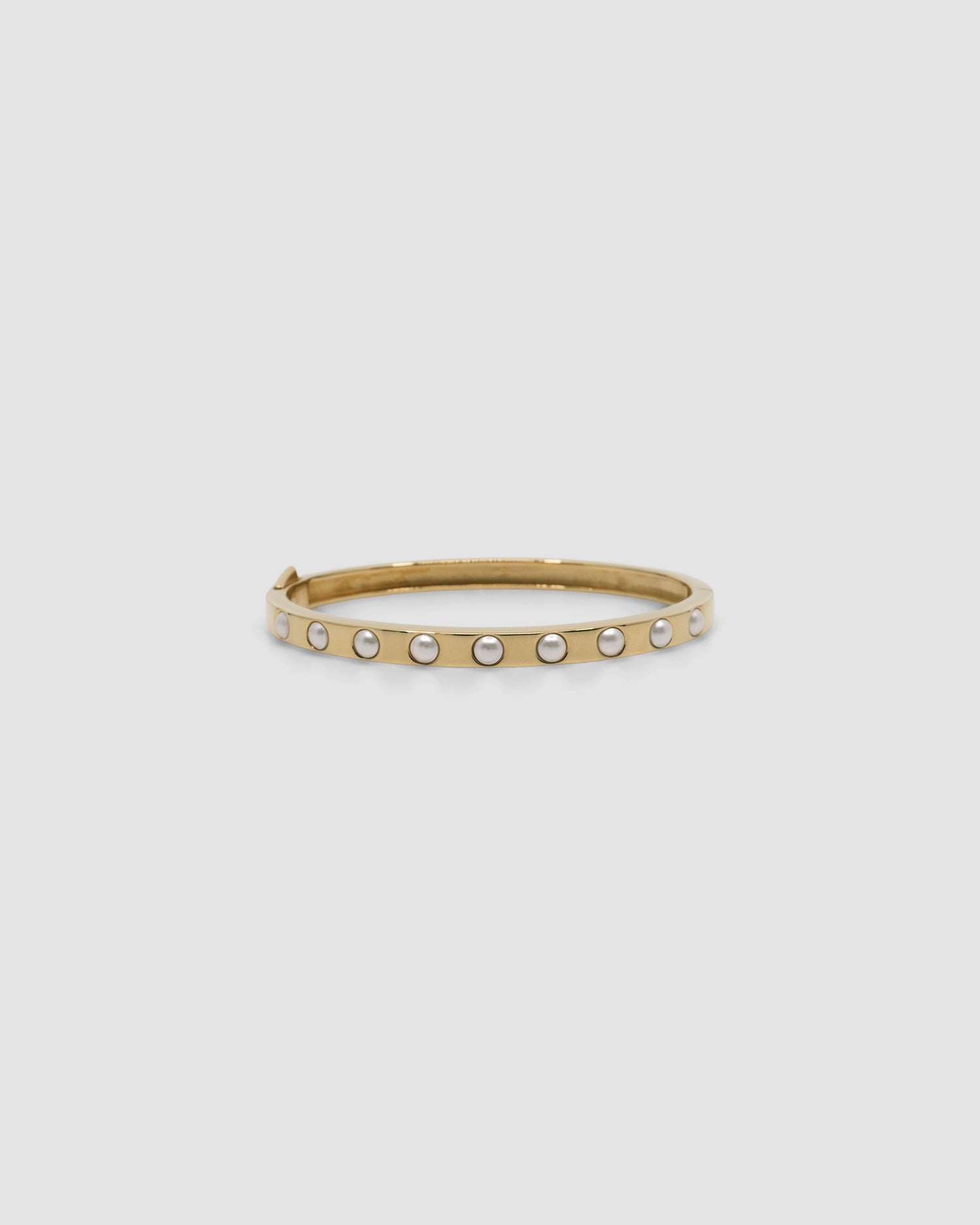 Gold bangle featuring inlaid pearls