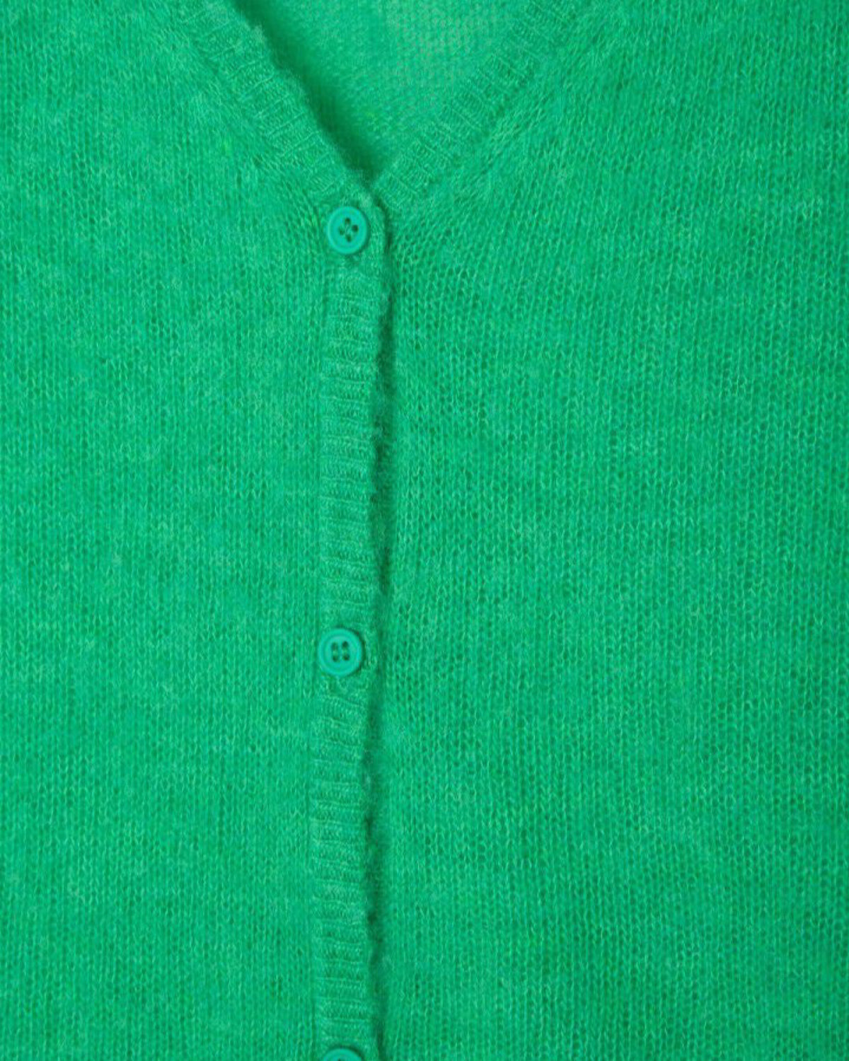 Close-up of a green cardigan with buttons on a green background