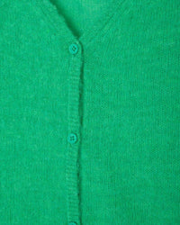 Close-up of a green cardigan with buttons on a green background